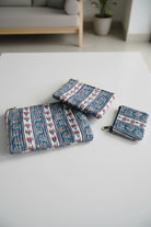 Set of three patterned pouches on a floral fabric background