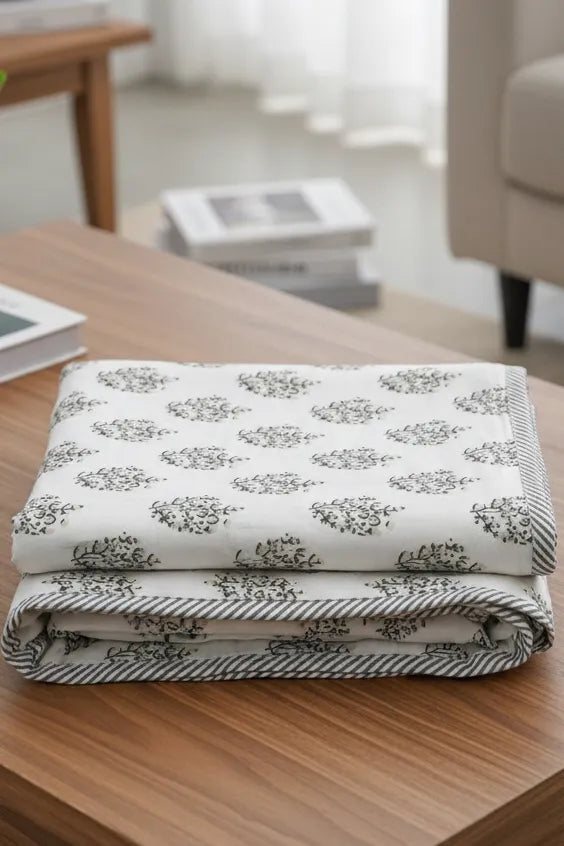 Folded blanket with a floral pattern on a wooden surface