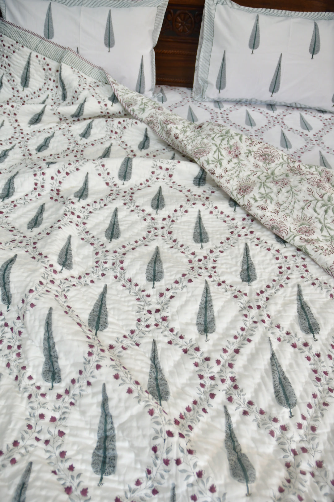 Floral patterned quilt with matching pillows on a bed