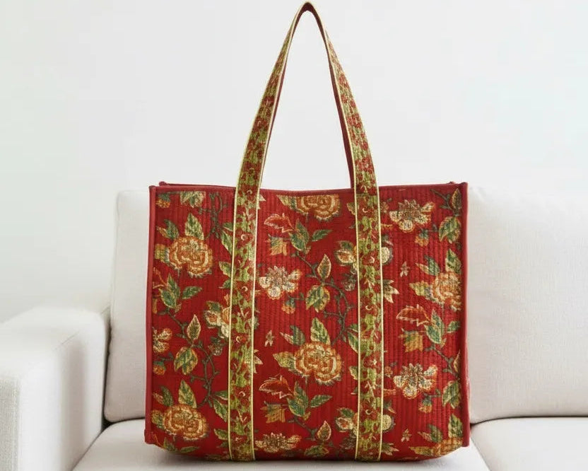 Red floral-patterned tote bag on a white couch