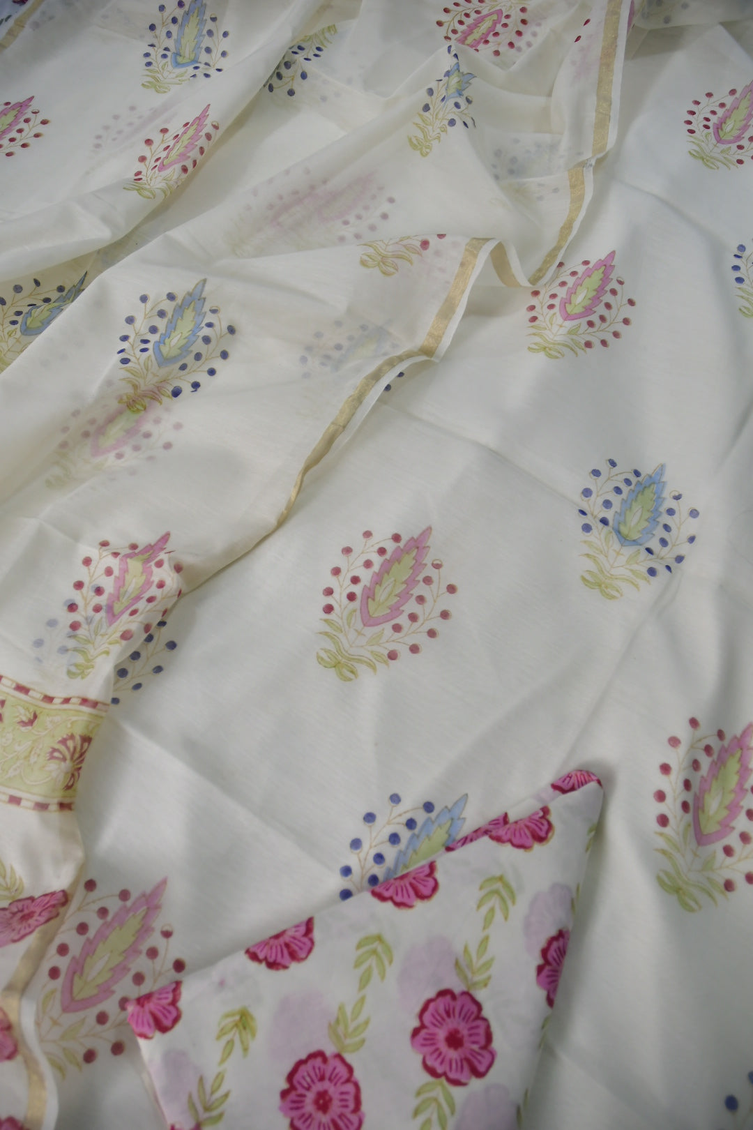 Floral patterned fabric with pink flowers and green leaves on a white background