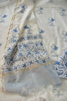 White fabric with blue floral patterns and a striped border.