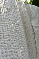 Close-up of a textured white quilt with a subtle pattern.