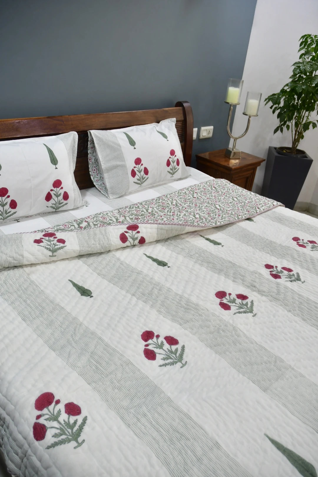 Floral patterned bedspread on a bed with matching pillows in a bedroom setting.