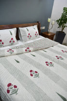Floral patterned bedspread on a bed with matching pillows in a bedroom setting.