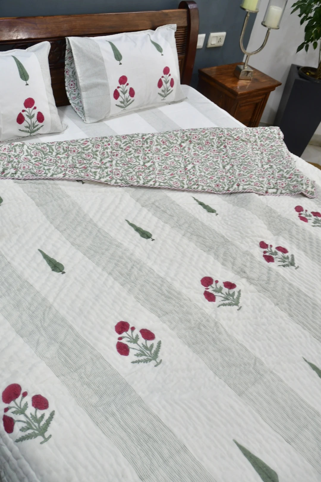 Floral patterned bedspread on a bed with matching pillows.