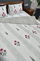 Floral patterned bedspread on a bed with matching pillows.