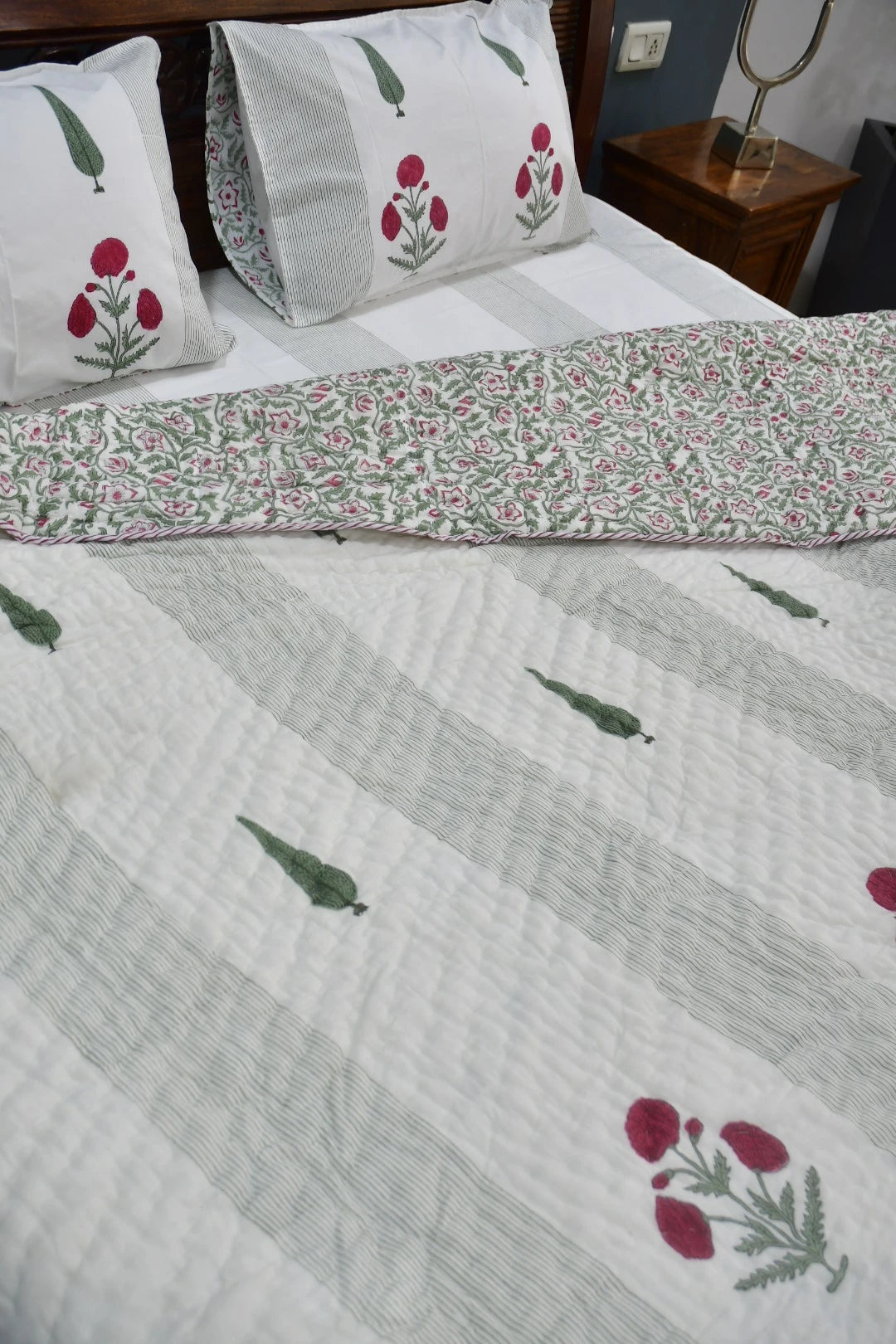 Floral patterned bedspread on a bed with matching pillows.