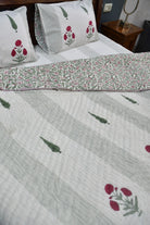 Floral patterned bedspread on a bed with matching pillows.