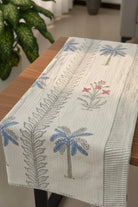 Table runner with palm tree and fern design on a wooden table