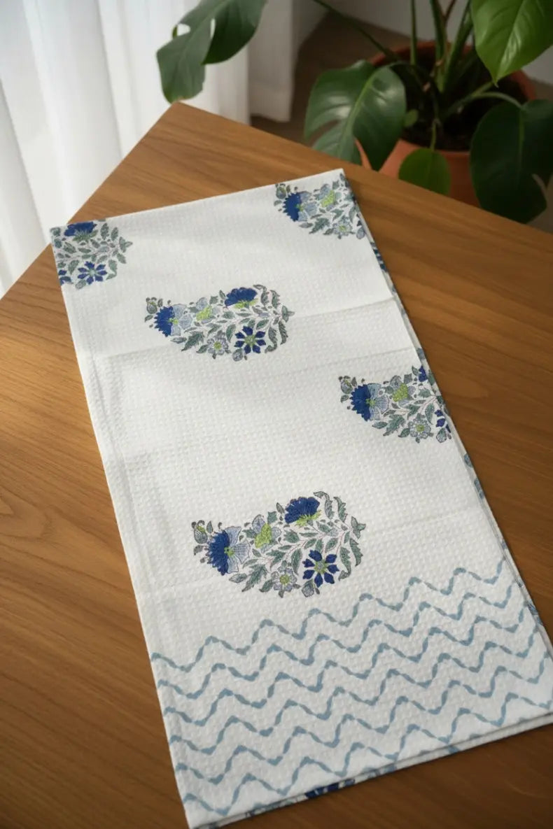 Decorative cotton towel and bath set with floral pattern on a wooden table