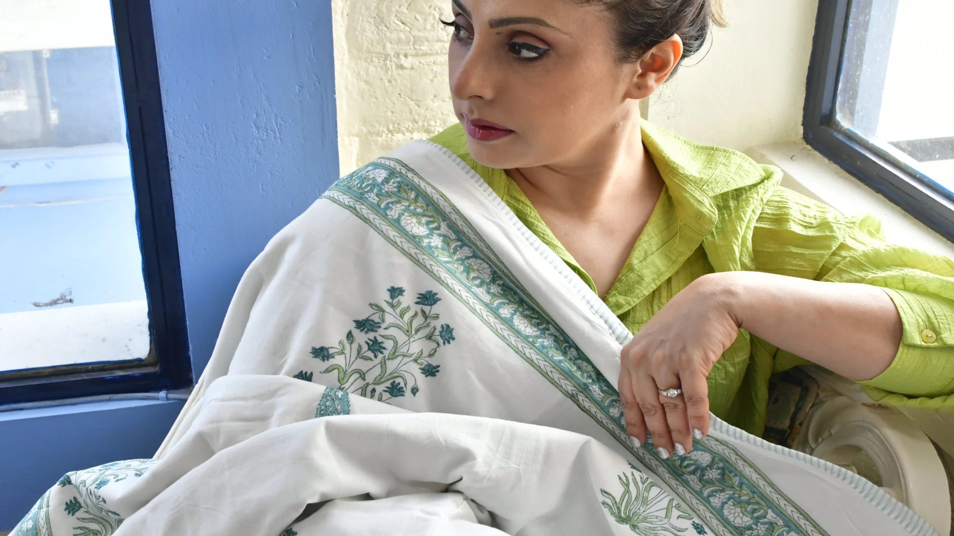 Woman wearing a white dohar with green patterns 
