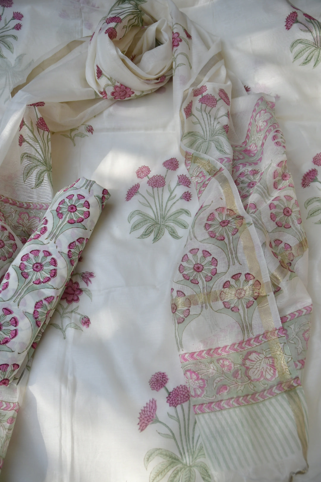 Floral patterned fabric with pink and green details on a white background