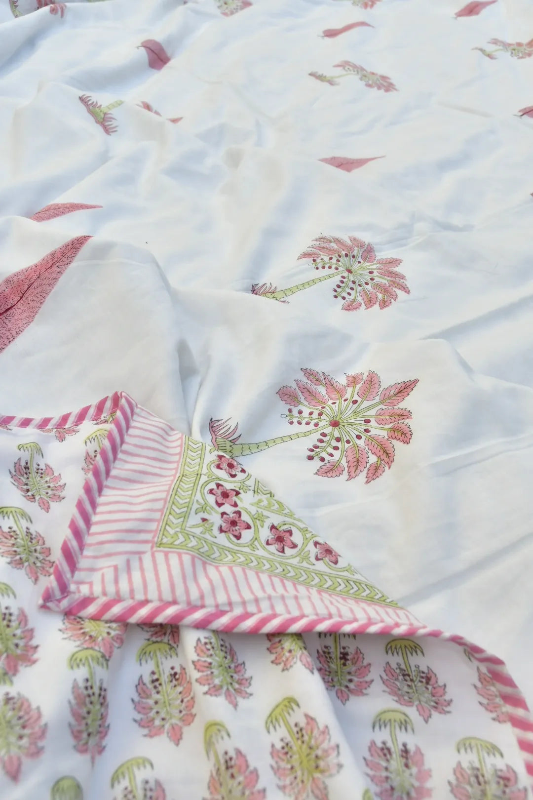 Floral and striped fabric with pink and green patterns on a white background