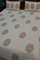 Floral patterned bedspread on a bed with matching pillows.