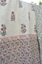 Floral patterned fabric with red and green designs on a white background