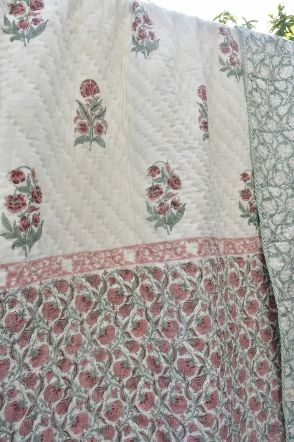 Floral patterned fabric with red and green designs on a white background