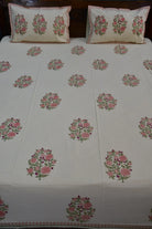 Floral patterned bedding with matching pillows on a bed.