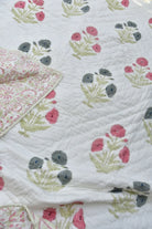 Floral quilt with pink and gray flowers on a white background