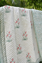Floral quilt with pink flowers on a green leafy background