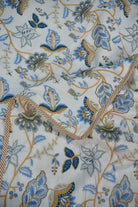 Floral and leaf pattern fabric with blue, brown, and beige colors on a white background