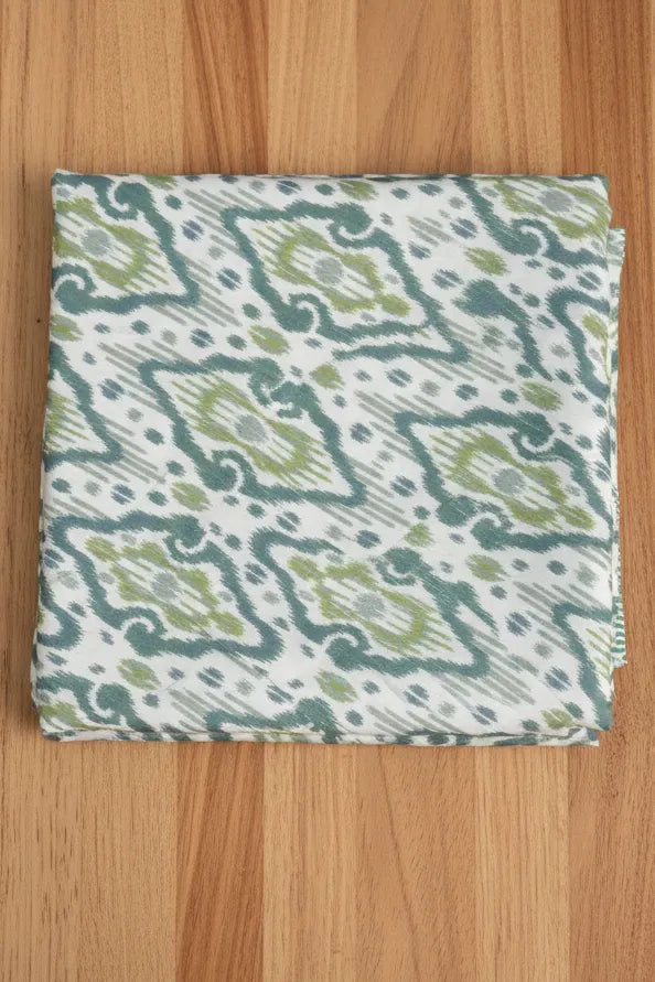 Folded dohar with a green and white pattern on a wooden surface