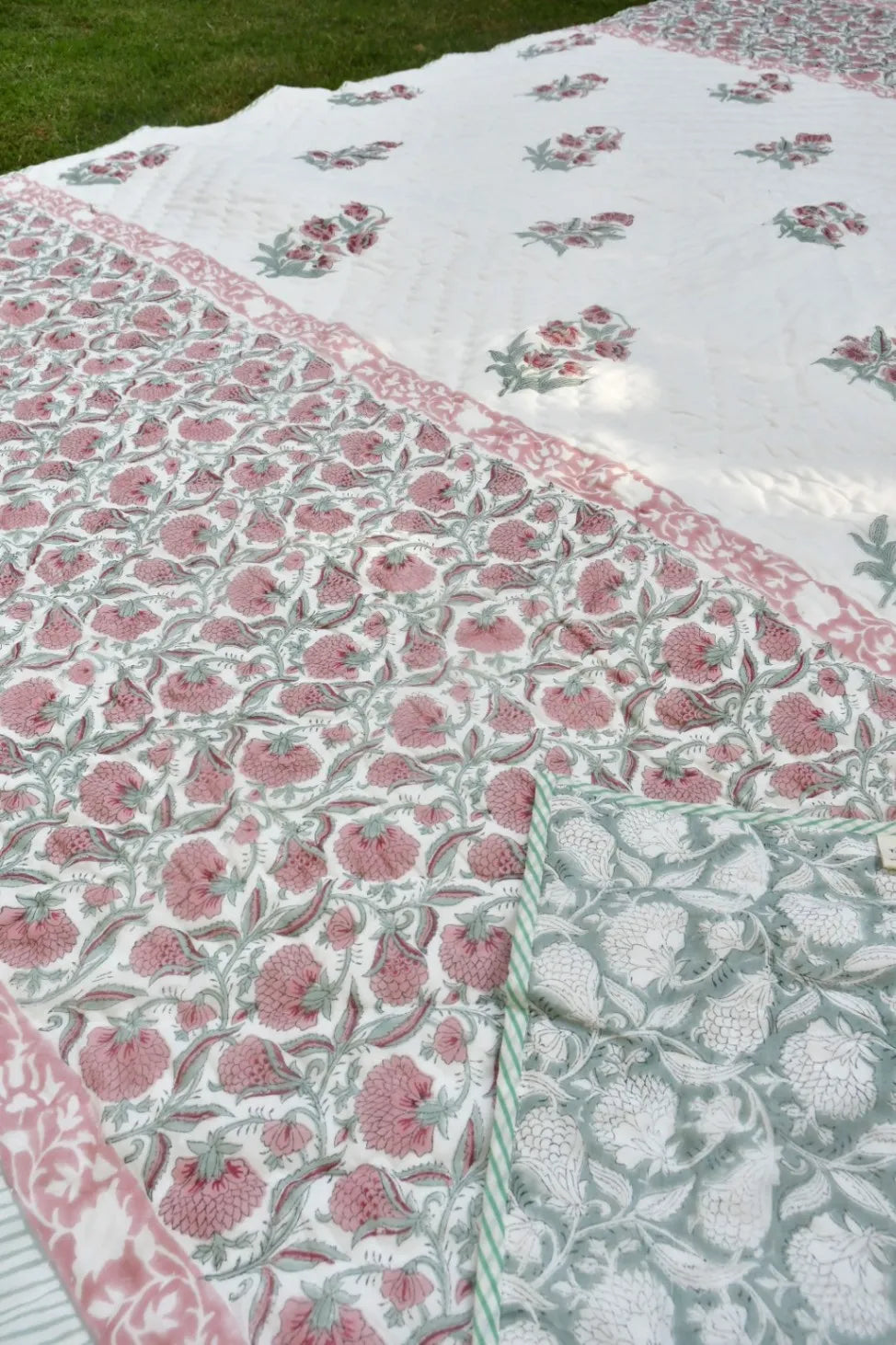 Floral patterned fabric with pink and green colors on a grassy background