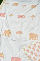 White soft dohar printed with pink elephants and pink umbrellas, with a matching patterned border visible along the top and bottom edges.