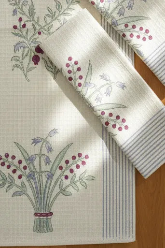 Floral-patterned tablecloth and napkin on a wooden surface