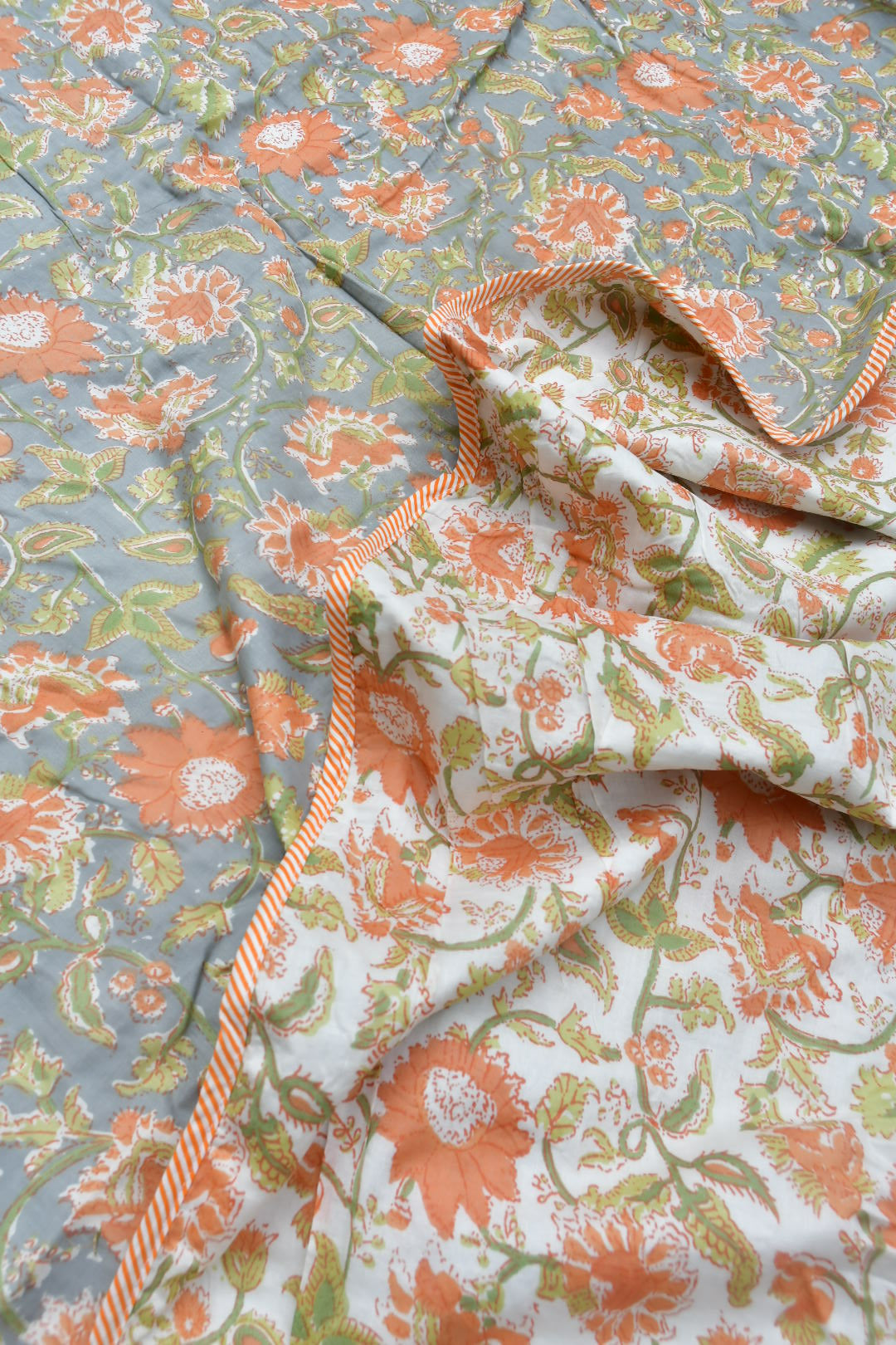 Floral patterned dohar with orange and green accents on a light blue background