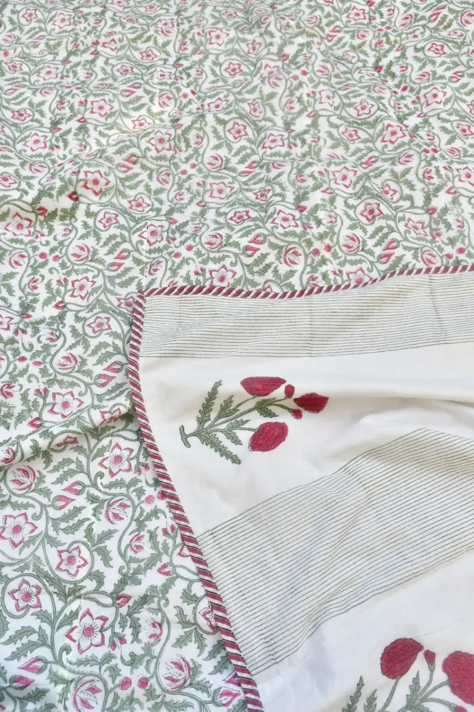 Floral fabric with a green and pink pattern on a white background