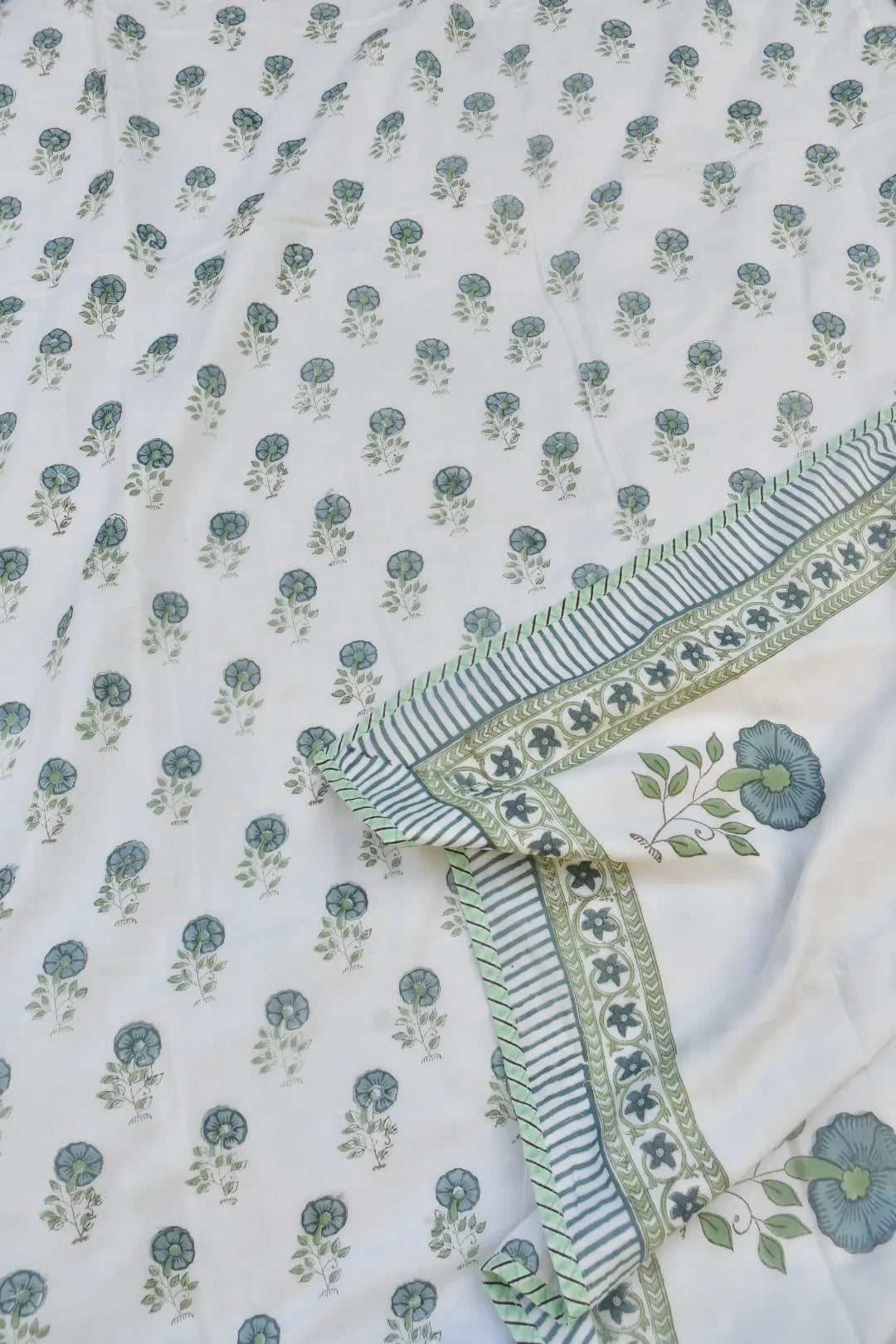 Floral patterned fabric with green and blue flowers on a white background