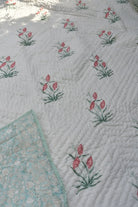 Floral patterned fabric with pink flowers and green leaves on a white background