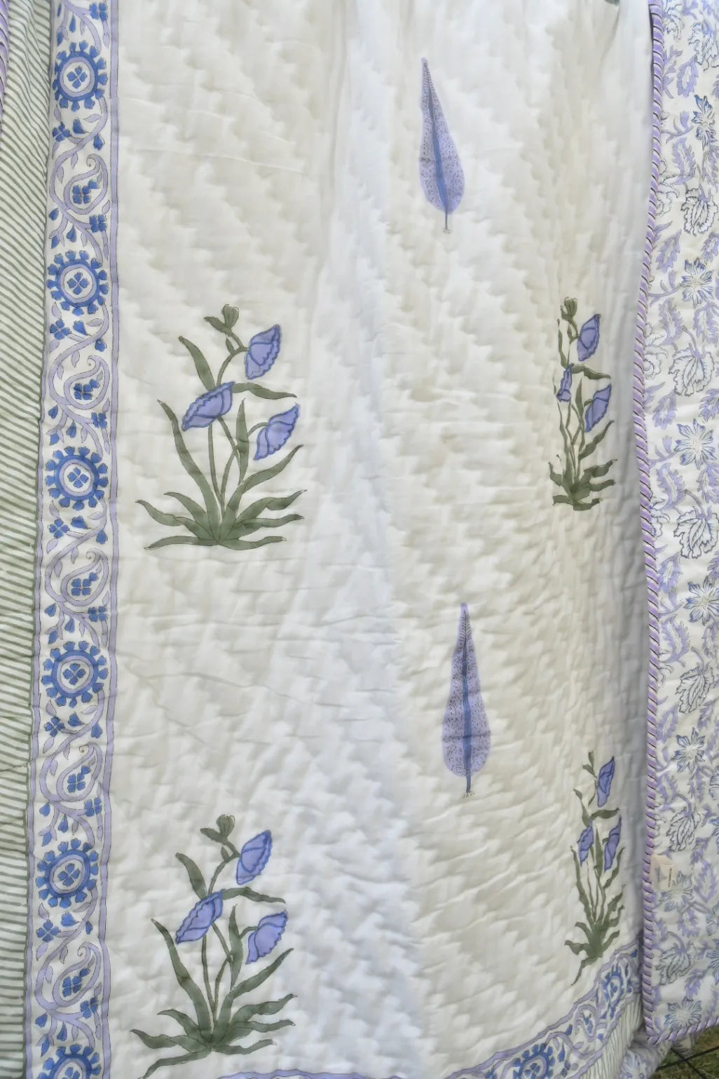 Quilt with floral embroidery on a white background