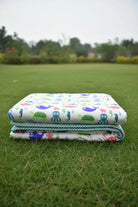 Stack of colorful children's dohar & blanket on grass