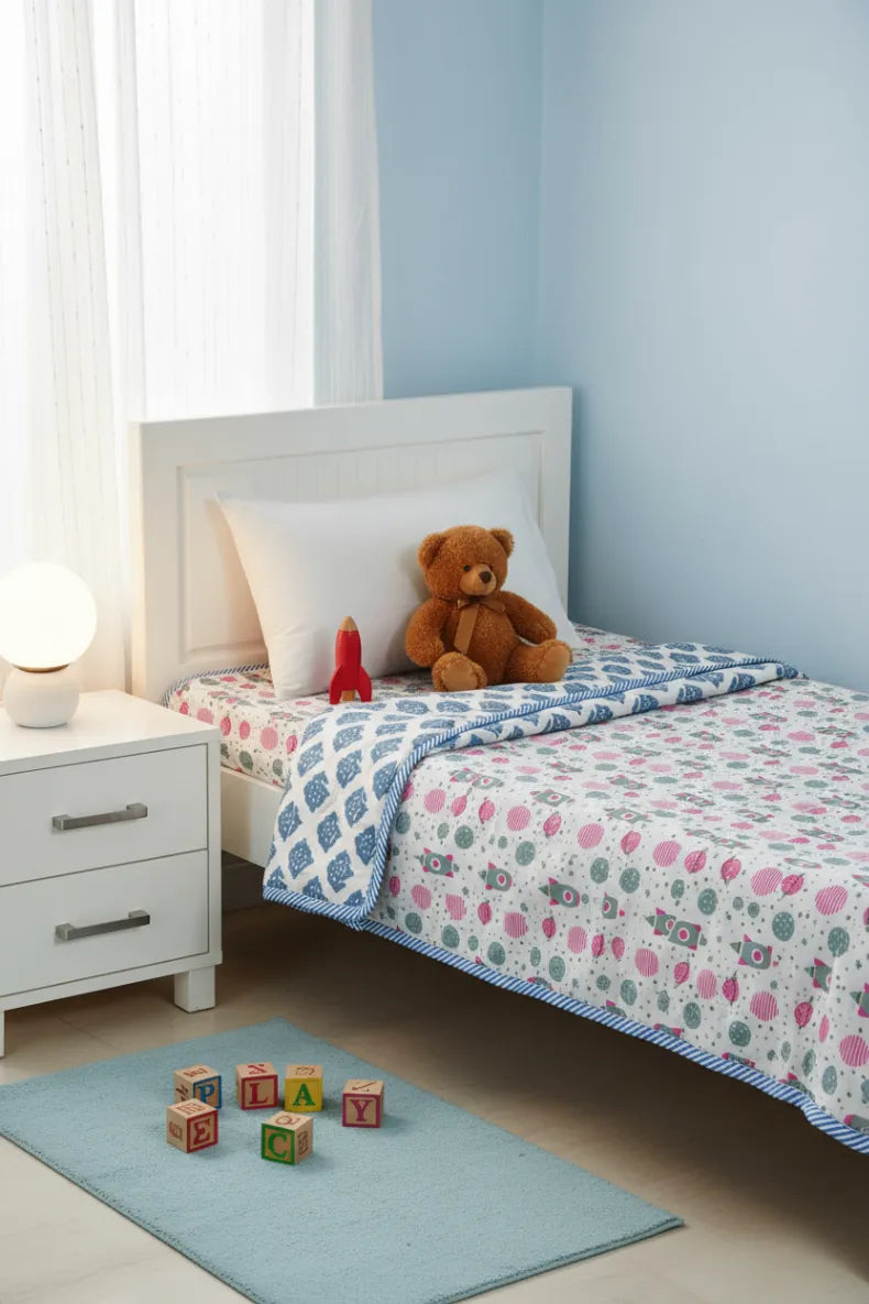 Children's bedroom with a bed, dohars, bedsheet bear, and alphabet blocks on a blue rug.