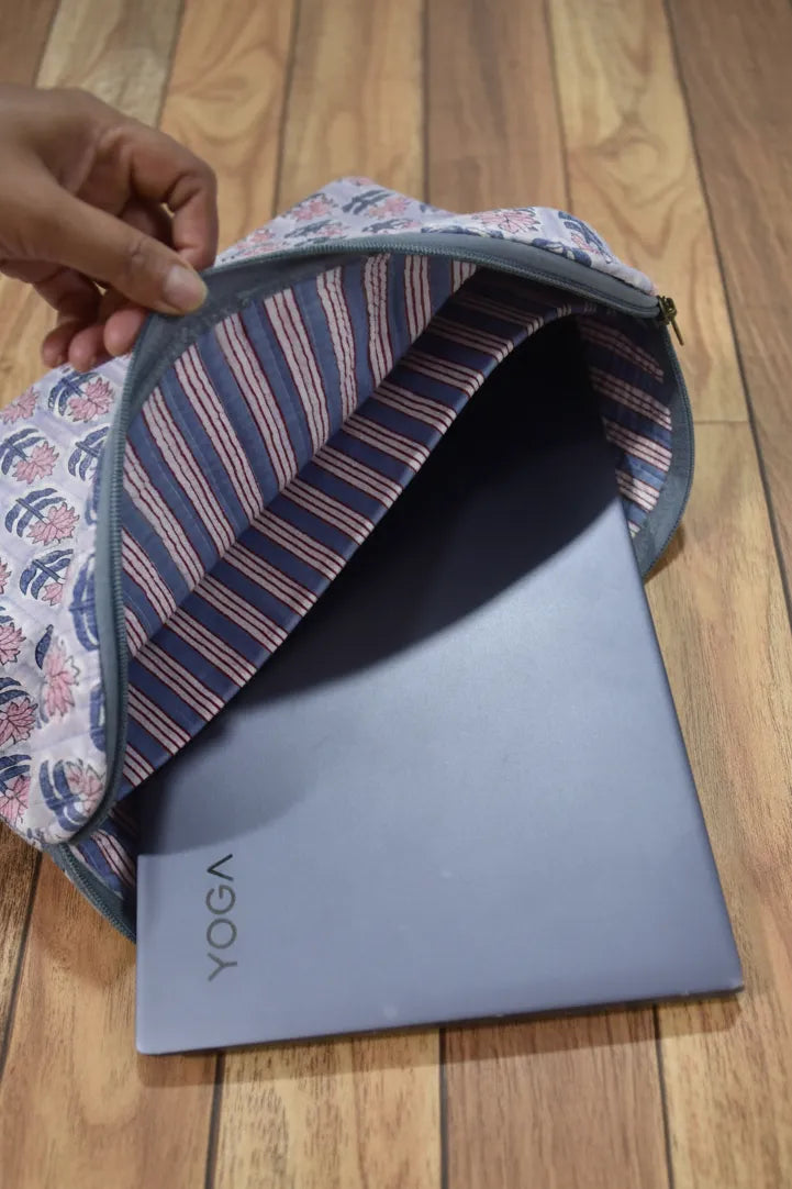 Laptop in a striped laptop bag & sleeve on a wooden floor