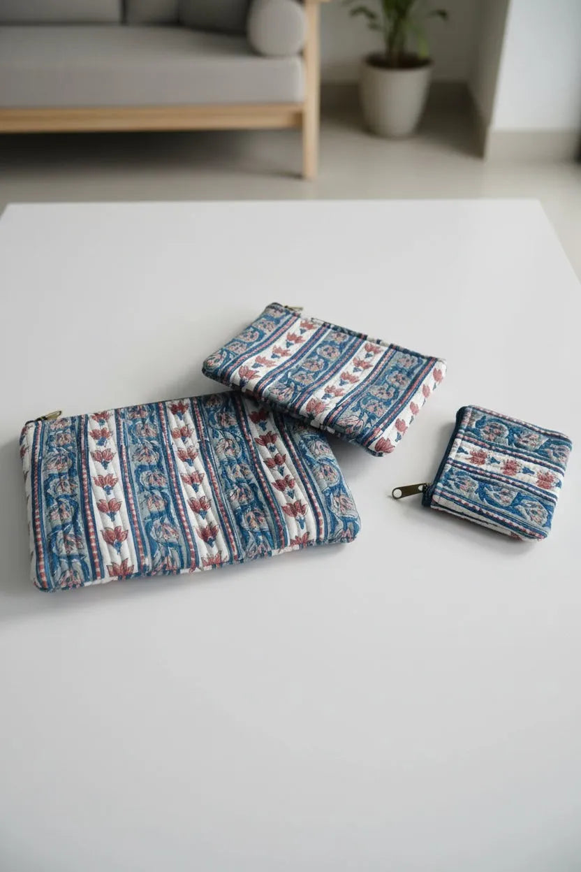 Set of three patterned pouches on a light gray surface with a blurred background