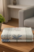 Folded Hand towel with palm leaf pattern on a wooden surface in a home setting
