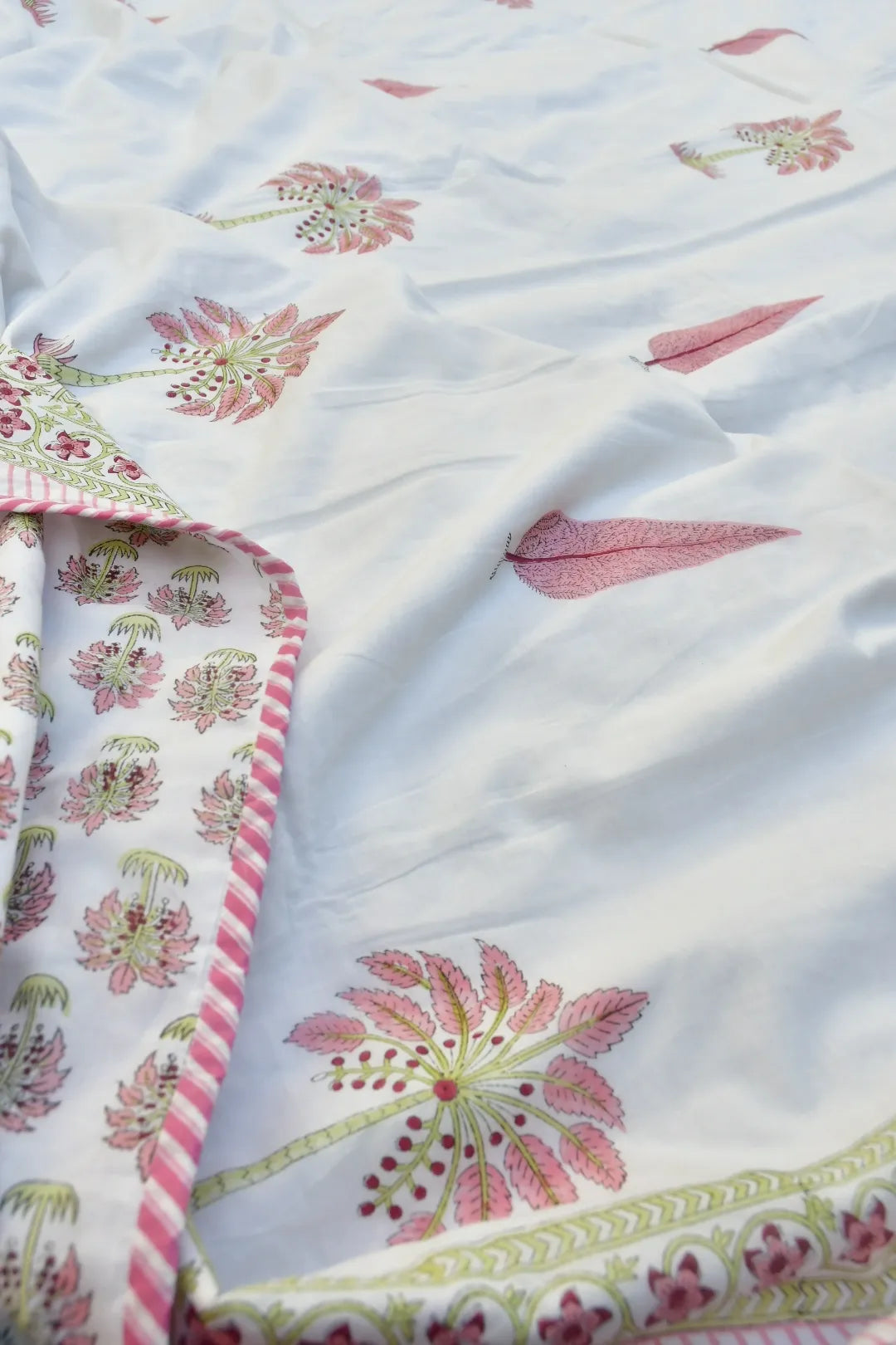 Floral patterned fabric with pink and green design on a white background