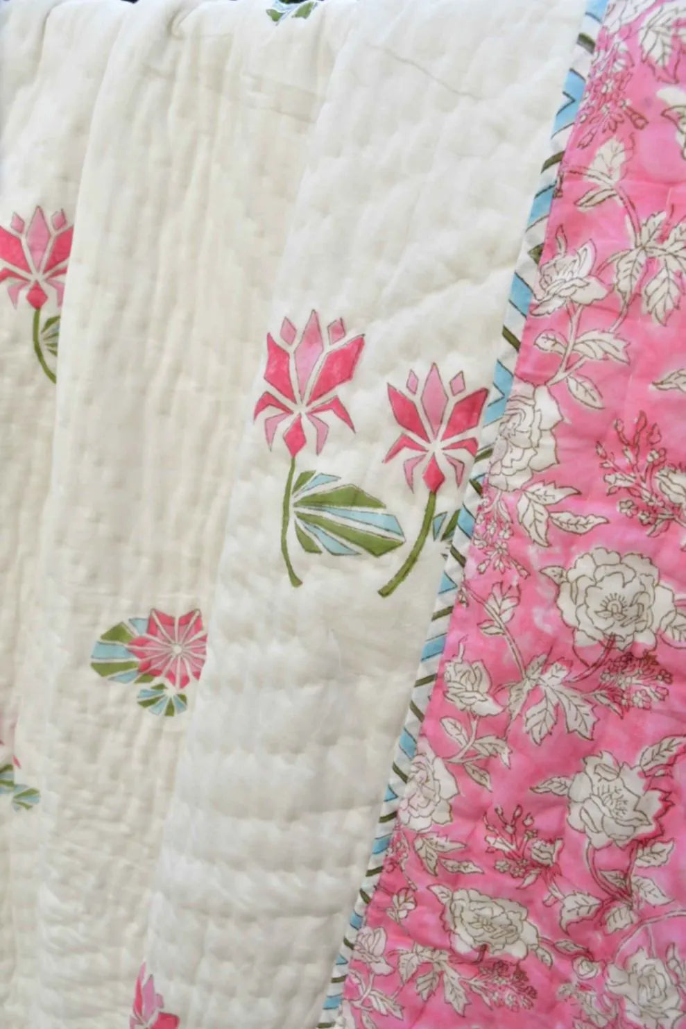 Close-up of a floral quilt with pink and white patterns