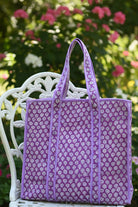Purple floral-patterned bag on a gray surface with a white background