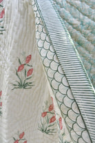 Close-up of a quilt with floral and geometric patterns.