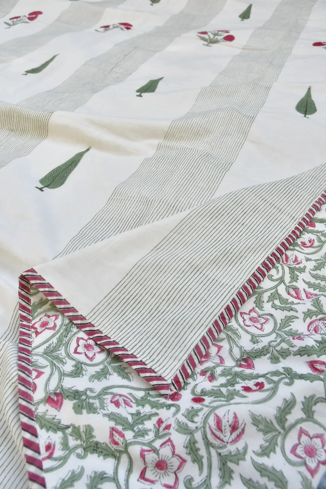 Close-up of a fabric with floral patterns and a striped border.