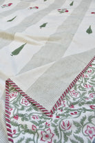 Close-up of a fabric with floral patterns and a striped border.