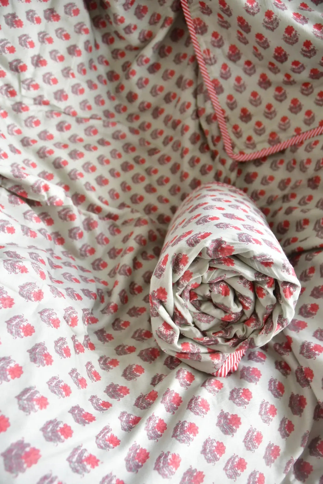 Floral-patterned fabric with a rolled-up section on a matching background