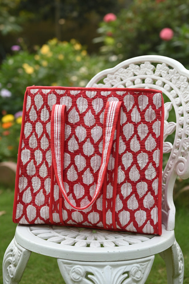 Red and white patterned bag on a floral-patterned surface