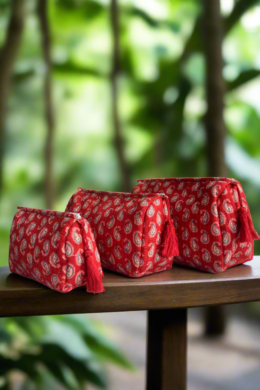 Red patterned bags on a wooden table with a blurred green background