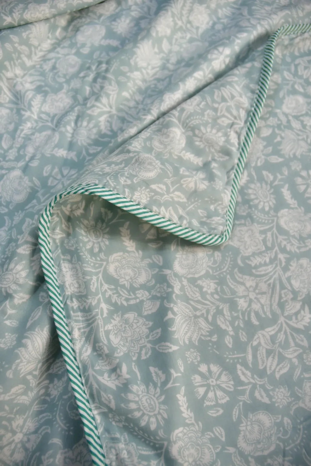 Floral fabric with a green and white striped ribbon on a matching background
