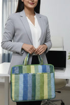 Woman holding a striped green and blue bag in an office setting